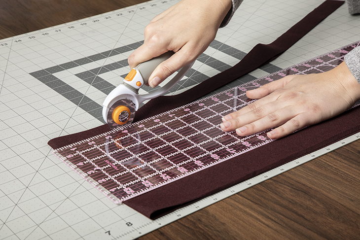 Cutting fabric with a rotary cutter.